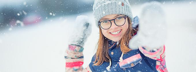 Mädchen hat Spaß bei Schneeballschlacht